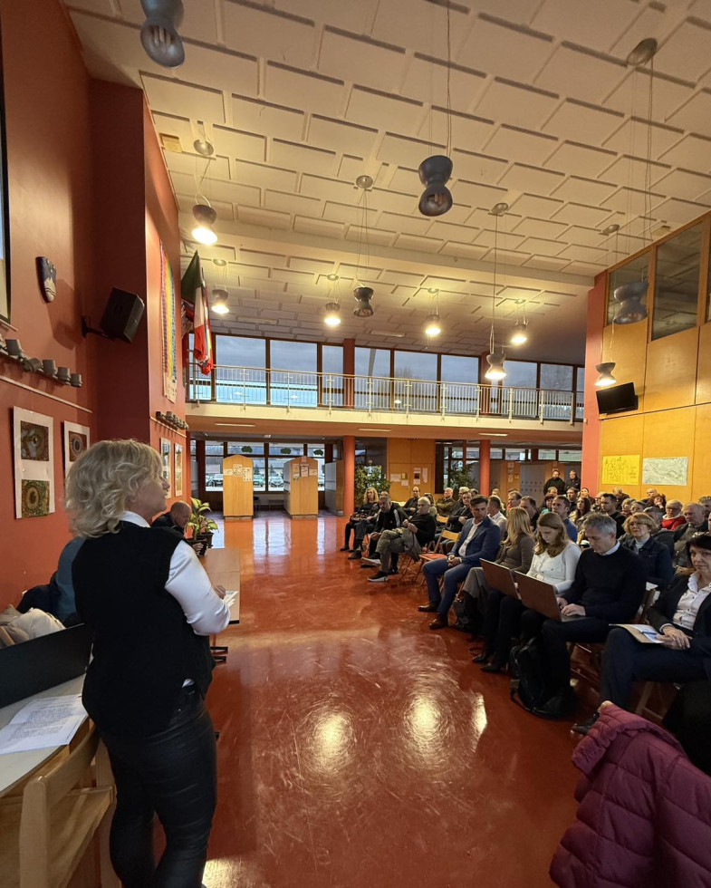 Person giving presentation of Flood Protection Measures in Dobova. People sitting in a large hall, listening.