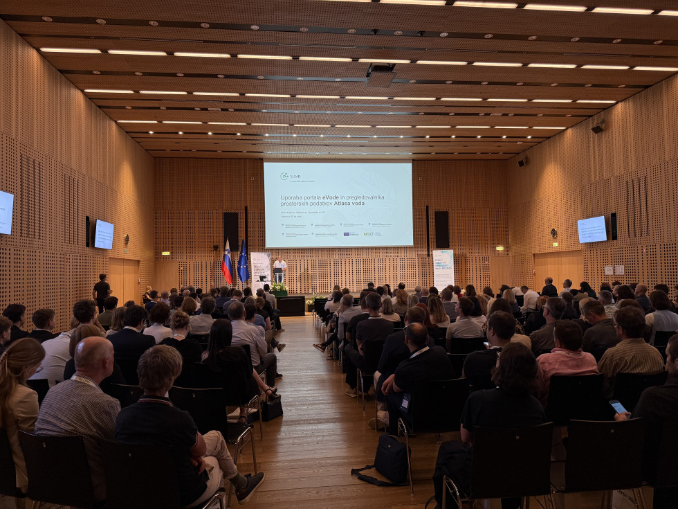 Udeleženci spremljajo predstavitev v konferenčni dvorani med strokovnim dogodkom.