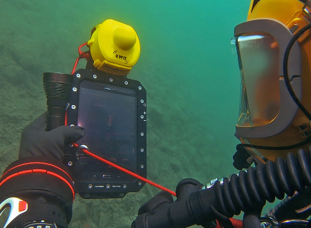 potapljač pod vodo gleda napravo