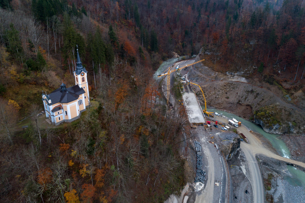 Slika iz ptičje perspektive, prikazuje gradnjo zadrževalnika in cerkvico na hribu.