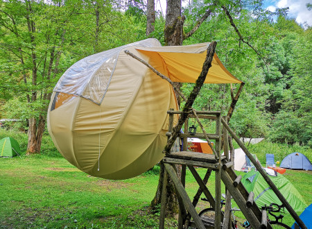rumen šotor okrogle oblike pritrjen na drevo