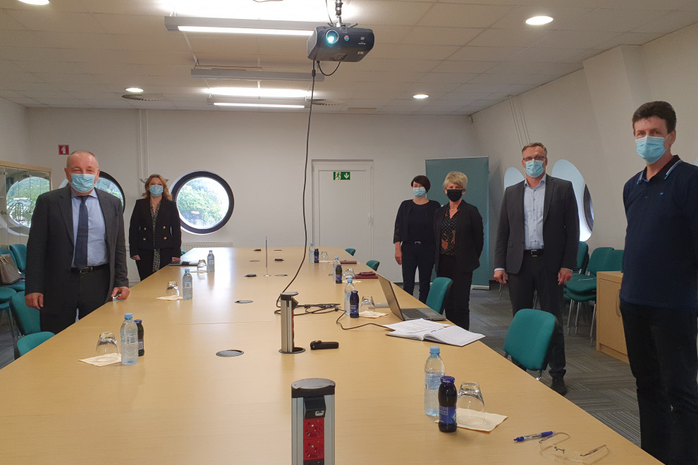 Fotografija je posneta v pisarni, v kateri  so minister Andrej Šircelj, vodja kabineta Urška Grmek, direktor Finančnega urada Dravograd Igor Švarc in dva njegova kolega. 