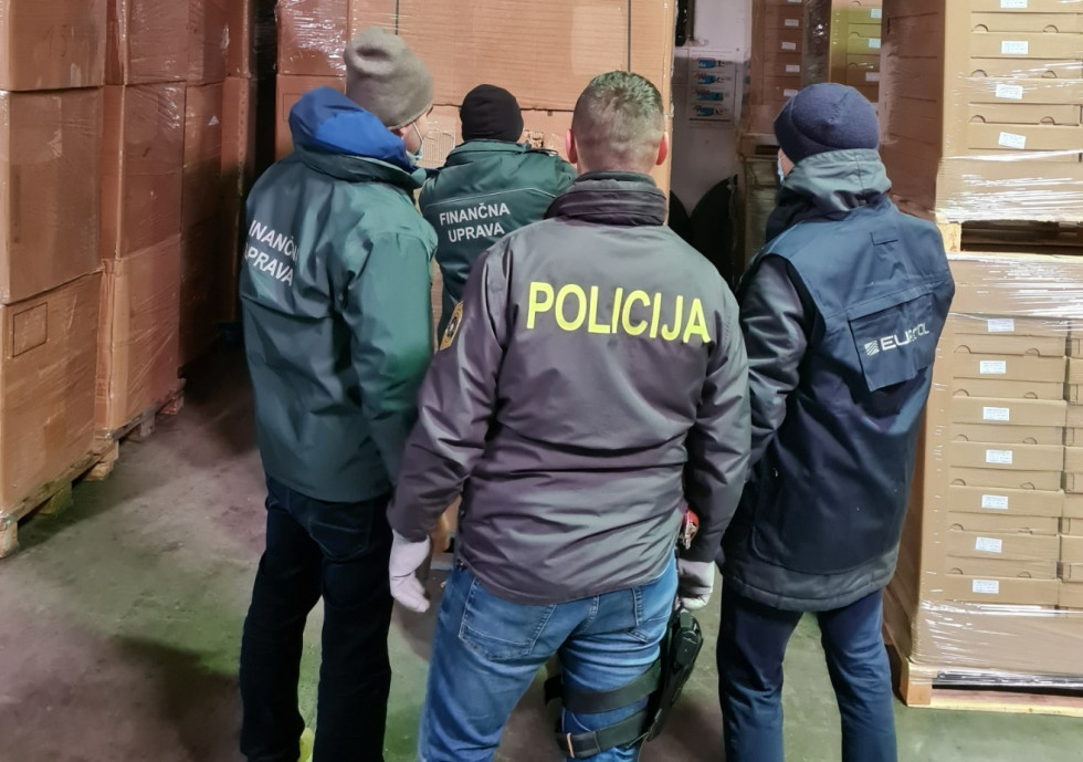 Uslužbenci Finančne uprave in Policije si ogledujejo škatle tobaka