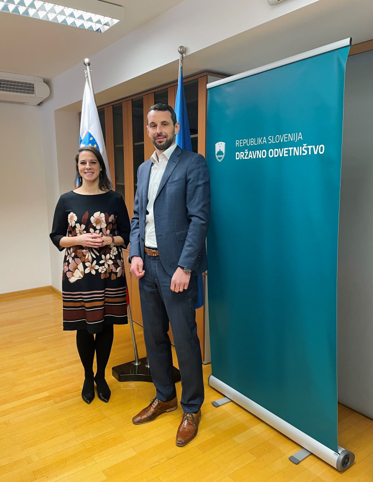 Pred zastavo Republike Slovenije stojita Peter Grum in Ana Kerševan