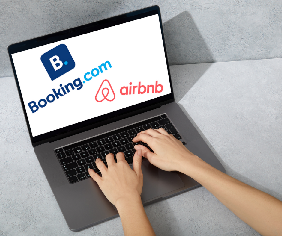 Slika je simbolična: prikazuje prenodni računalnik, na katerem sta znaka podjetij Booking.com in airbnb