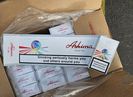 Odprta šakrtonasta škatla s cigareti in vidna znamka "Ashima"