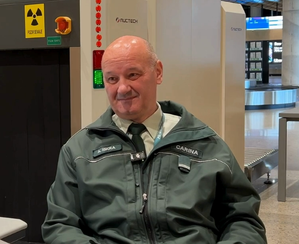 Moški sedi v zeleni službeni obleki.