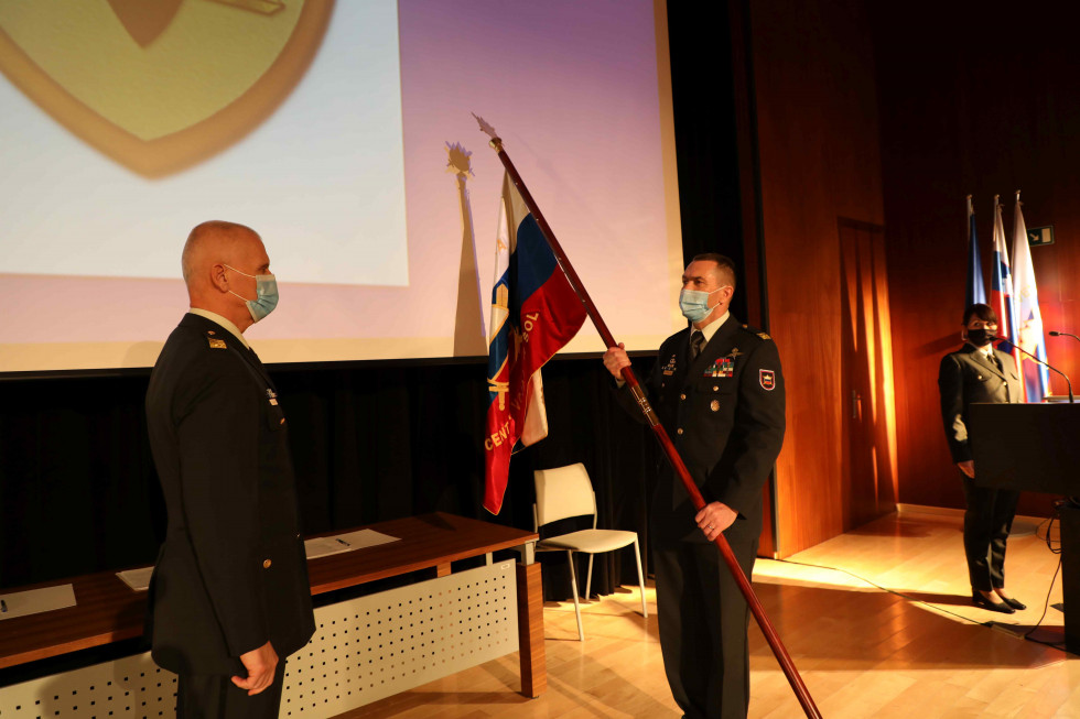 Brigadir Peter Zakrajšek v rokah drži bojni prapor Centra vojaških šol, ki mu ga je predal načelnik Generalštaba Slovenske vojske generalmajor Robert Glavaš.