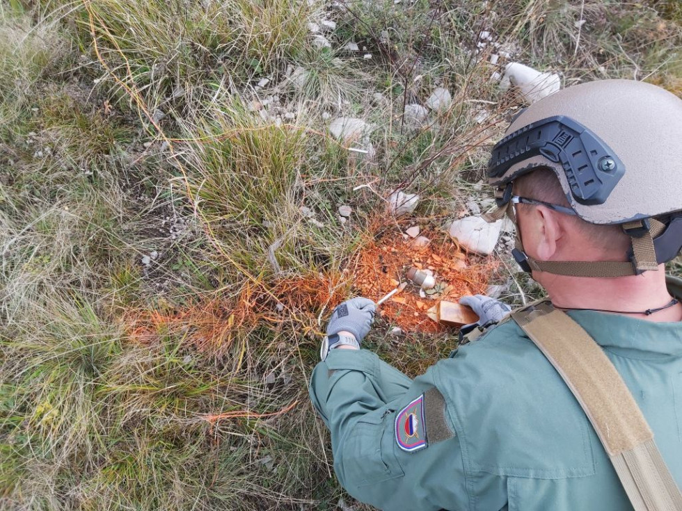 Pirotehnik Slovenske vojske odstranjuje minsko eksplozivno sredstvo na travniku Osrednjega poligona Slovenske vojske Postojna