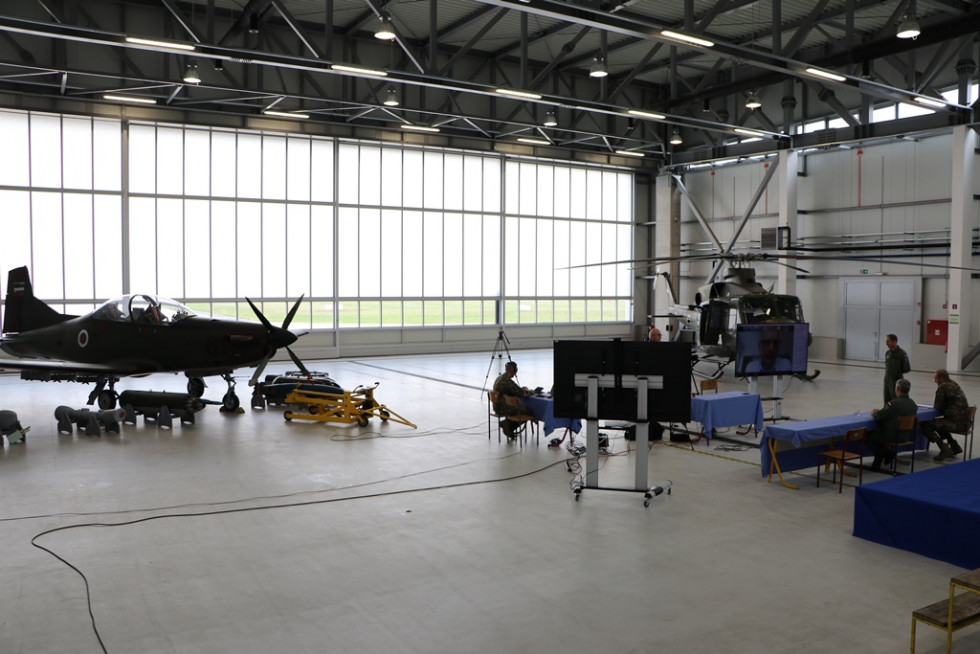 Novinarska konferenca v letališkem hangarju z letalom Pilatus PC-9 in helikopterjem Bell-412