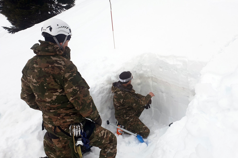 Pripadnika SV izvajajta meritev stabilnosti snega