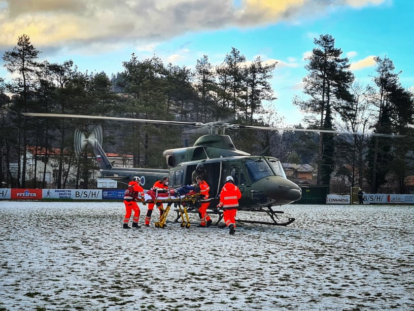 Na helikopter Slovenske vojske nalagajo obolelo osebo, ki potrebuje hitro nujno medicinsko pomoč.