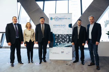 Organizacijska ekipa 8. slovenskega INSPIRE dneva ob reklamnem panoju konference