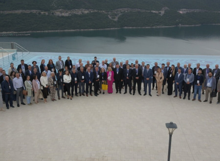 Skupinska slika zunaj pred konferenčnim centrom, v ozadju je morje