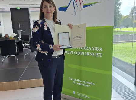 mag. Erna Flogie Dolinar, predstavnica Geodetske uprave na Brdu pri Kranju, kaže Plaketo in diplomo civilne obrambe, ki ju je Geodetska uprava prejela za prispevek k razvoju, delovanju in opravljanju nalog civilne obrambe Republike Slovenije