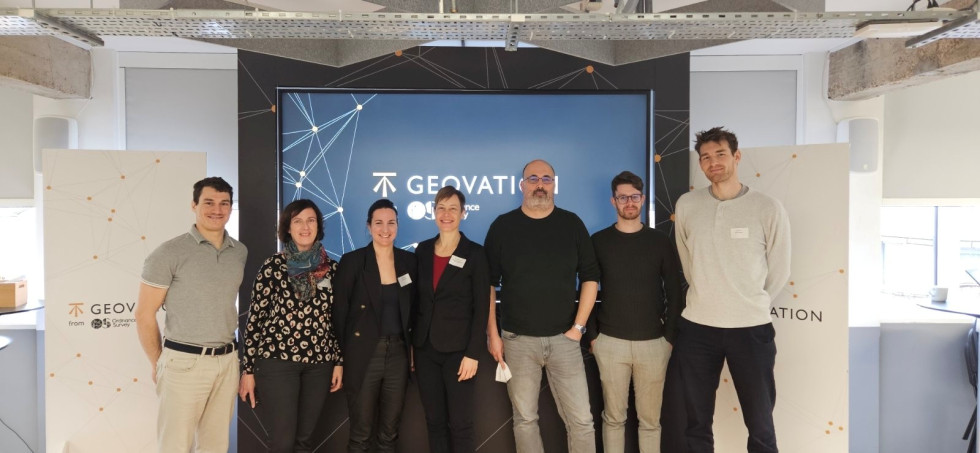 Tri ženske in štirje moški - predstavniki Slovenije stojijo pred zaslonom na dogodku