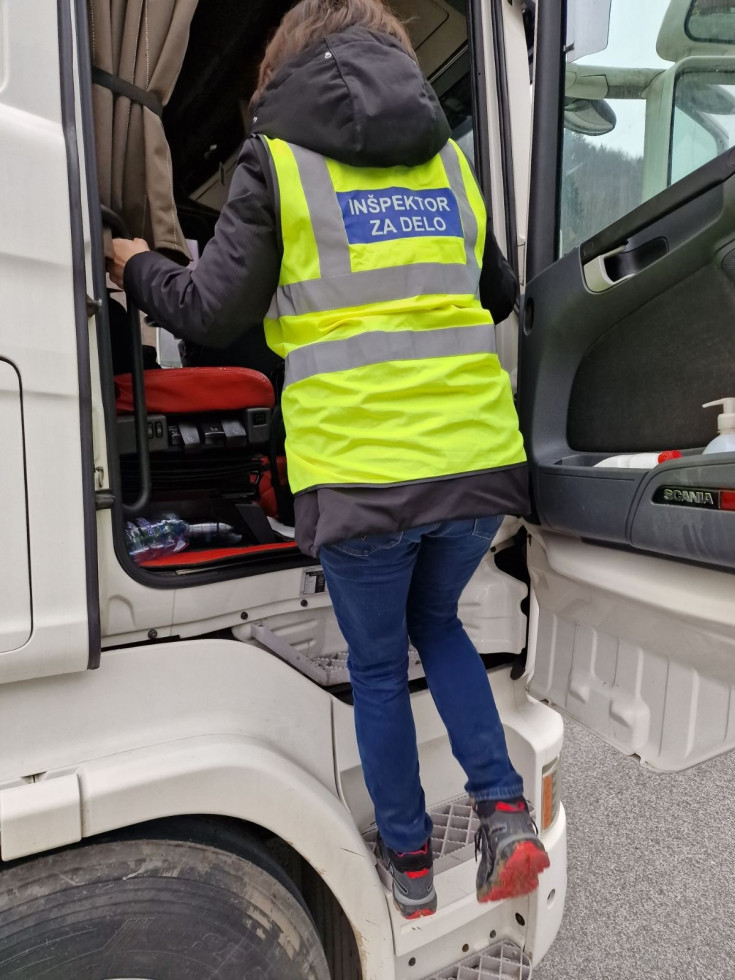 The inspector enters the lorry to check the licences.