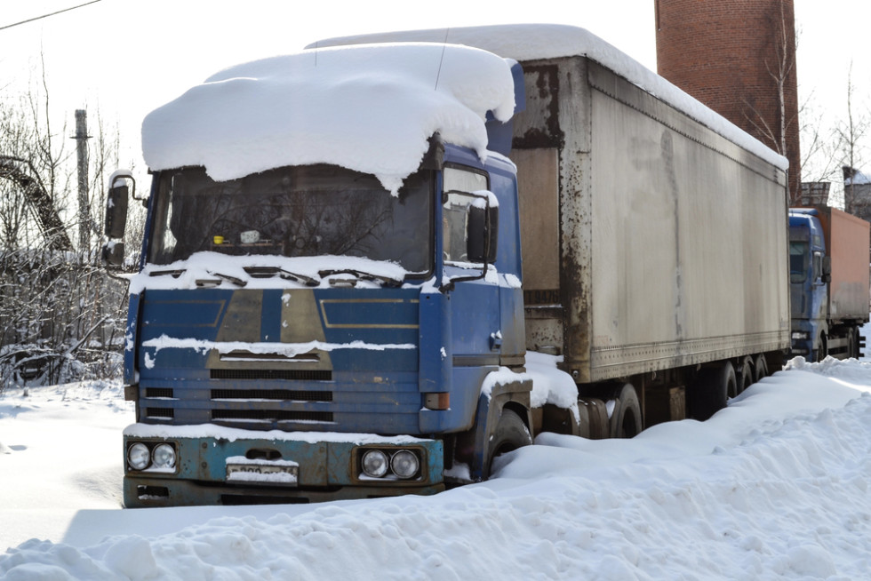 A parked lorry with snow on the cab and trailer