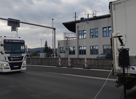 Ob vozišču nameščena oprema za komunikacijo na daljavo, ki očitava mimo vozeča tovorna vozila