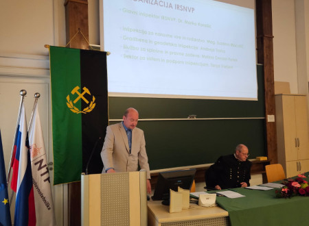 Simon Friškovec (levo) za govorniškim pultom 