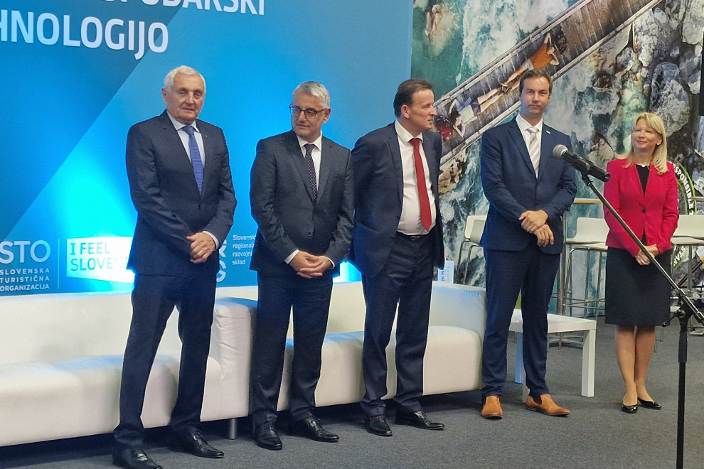 Minister za gospodarski razvoj in tehnologijo Matjaž Han s še tremi predstavniki stojijo na razstavnem prostoru ministrstva na sejmu MOS