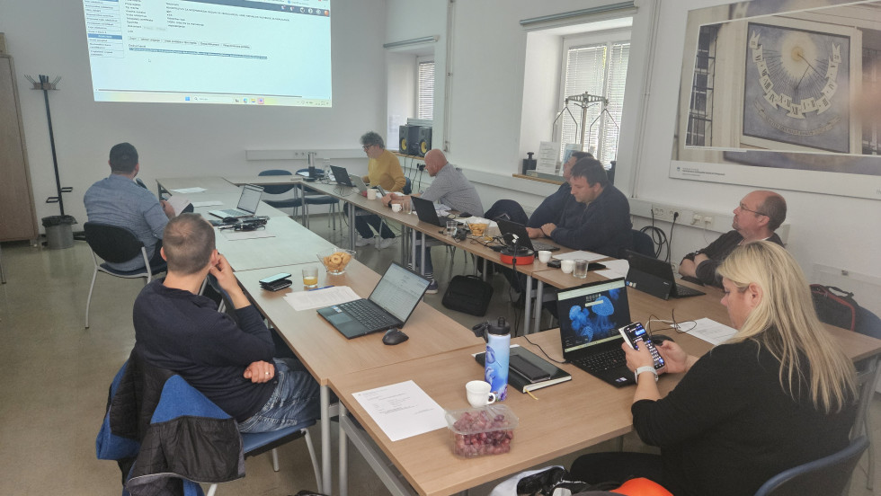 V sejni sobi za mizo sedijo udeleženci usposabljanja.