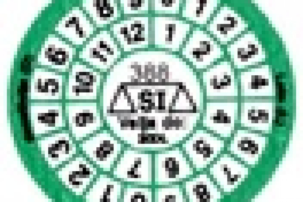 Green circle with a circular calendar in it. From the outside in, the dials are following for years and months, and in the middle, there is a scale marked with SI.