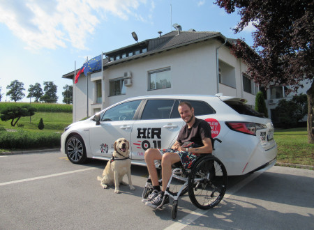 Luka Plavčak s spremljevalcem psom pred belim avtom na parkirišču pred zaporom na Dobu