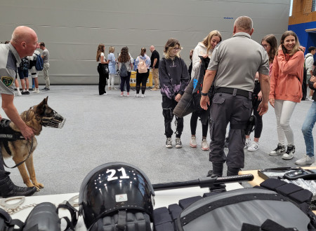 Pravosodni policisti učenkam predstavljajo opremo za delo s službenim psom