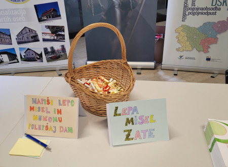 Košara, v kateri so lepe misli, v ozadju predstavitveni plakati razstavljavcev