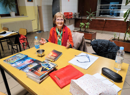 Danica Zlatar obkrožena s knjigami na dogodku v Odprtem oddelku Rogoza