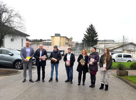 Direktor zavoda in ravnatelj, skupaj s predstavniki srednje šole pred vhodom v zapor, v rokah vsi držijo knjige