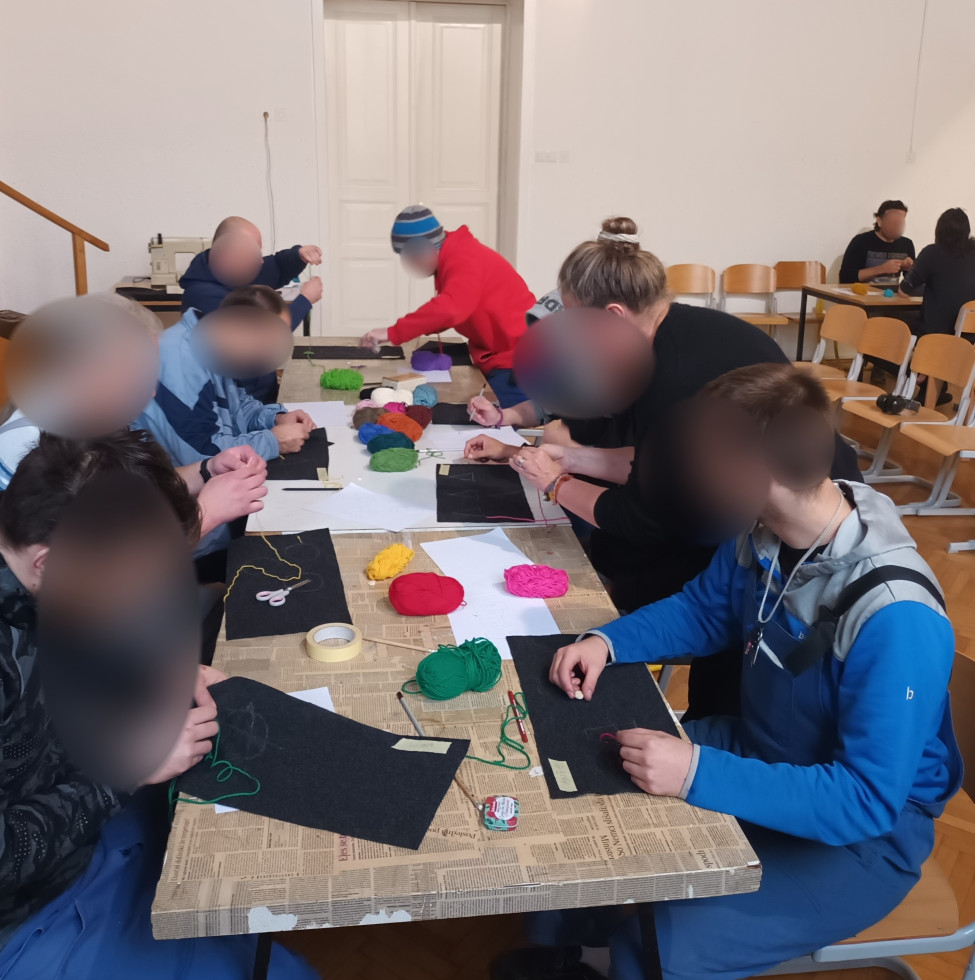 Udeleženci na delavnici v parih izdelujejo mehke blazine.
