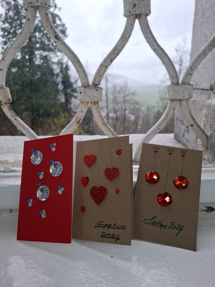 Na okenski polici so postavljene tri voščilnice, ki so okrašene s srčki