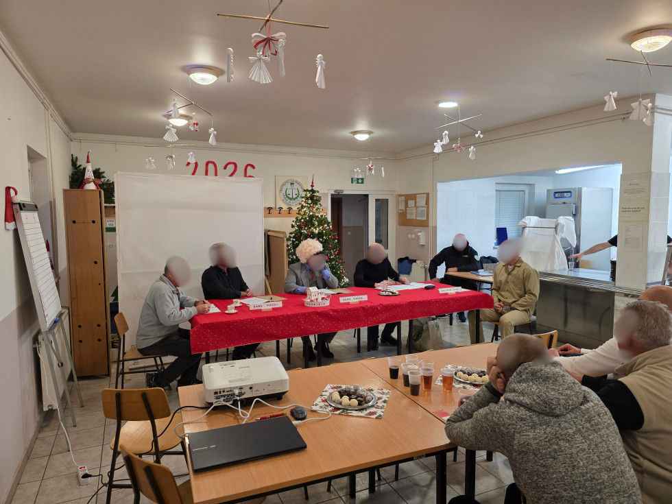 Na sliki so postavljene mize, kjer so zbrani navzoči na čajanki. Na mizah je čaj in sladice.