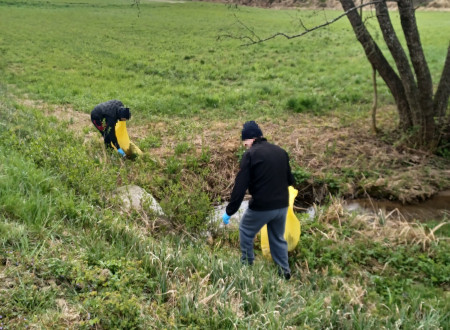 Obsojenci pobirajo smeti na travniku, ob potoku