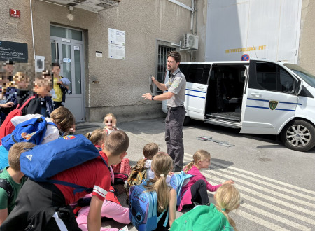 Pravosodni policist pred zavodom predstavlja naše delo skupini osnovnošolcev