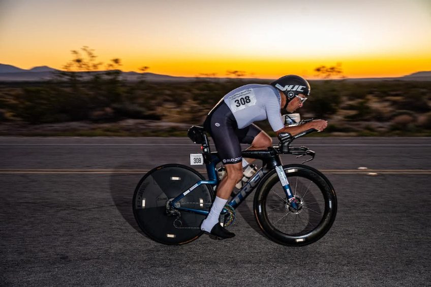 Na sliki je Stanislav Verstovšek na kolesu med tekmo. V ozadju je sončni zahod.