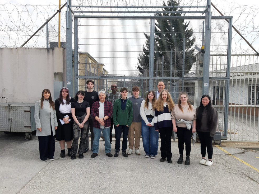 Slika prikazuje študente in profesorje pred zaporom Dob pri Mirni.