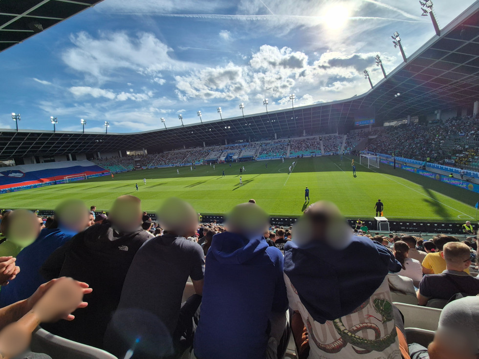 Nogometni stadion v Stožicah. Poteka nogometna tekma. Tribune so polne. Na njih je tudi nekaj mladoletnikov iz Prevzgojnega doma Radeče.