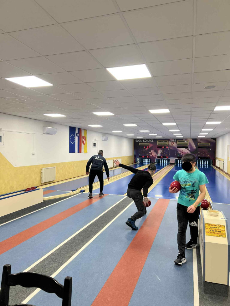 Na sliki so zaprte osebe med kegljanjem