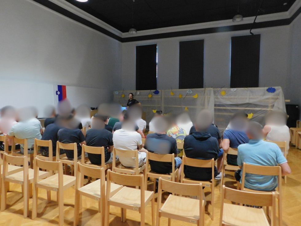 Udeleženci, ki jih je kakšnih 30, sedijo na delavnici in sodelujejo na delavnici.