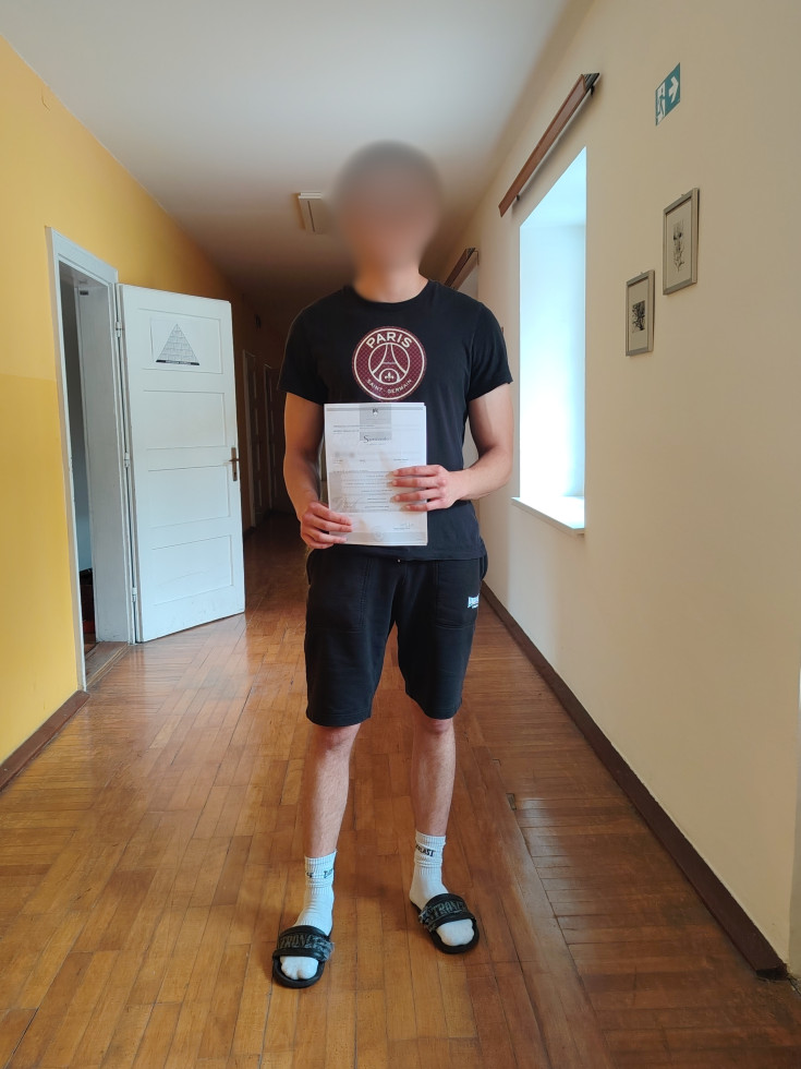 Na sliki je mladoletnik, ki je uspešno opravil poklicno maturo. V rokah drži spričevalo