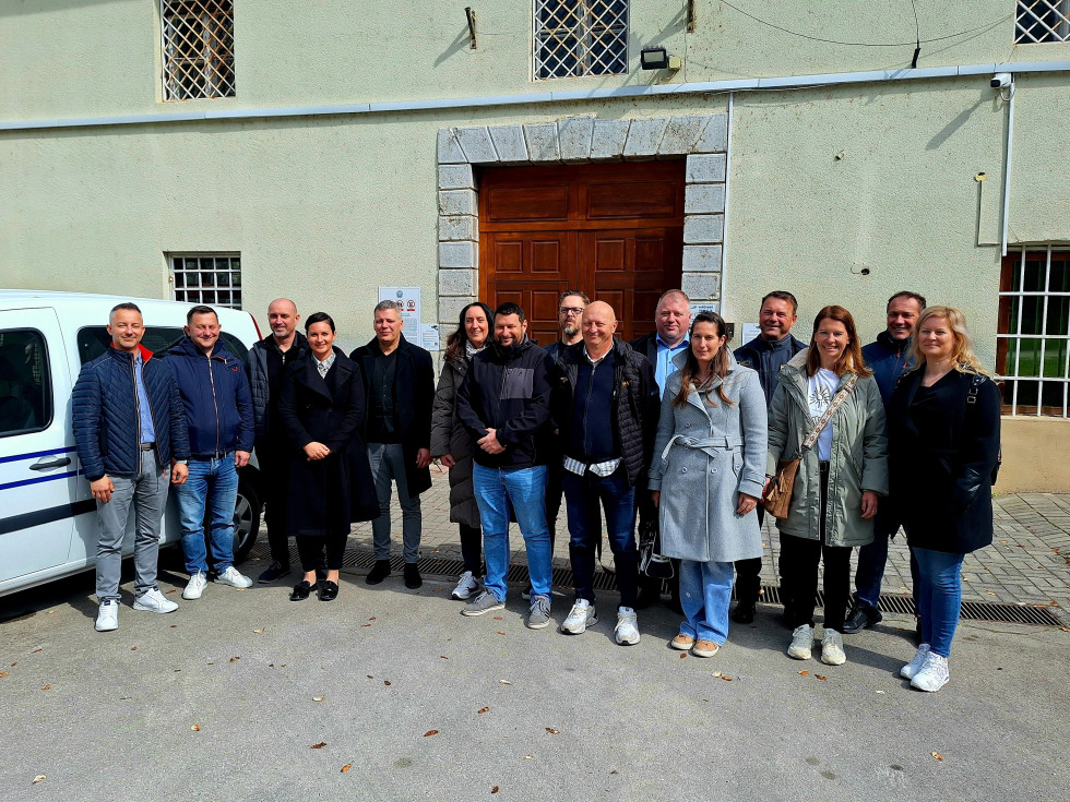 Na sliki je skupina vseh udeležencev in gostiteljev obiska pred Prevzgojnim domom Radeče