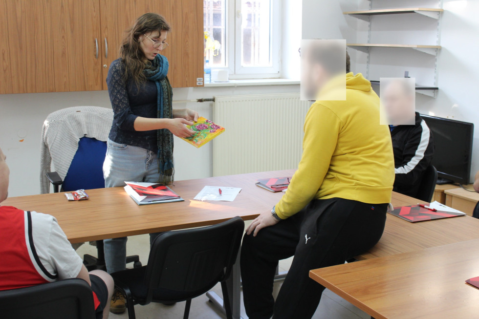 Na sliki sta dva udeleženca v programu in predavateljica med razlago.