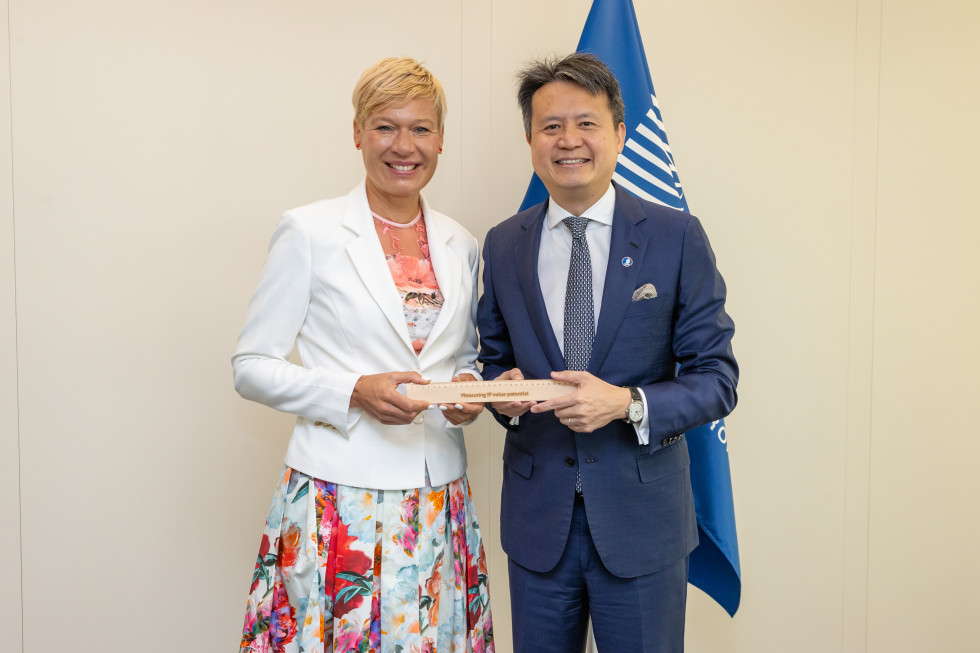 oba direktorja pozirata, se smehljata, v roki pa skupaj držita leseno ravnilo z napisom measuring IP value potential