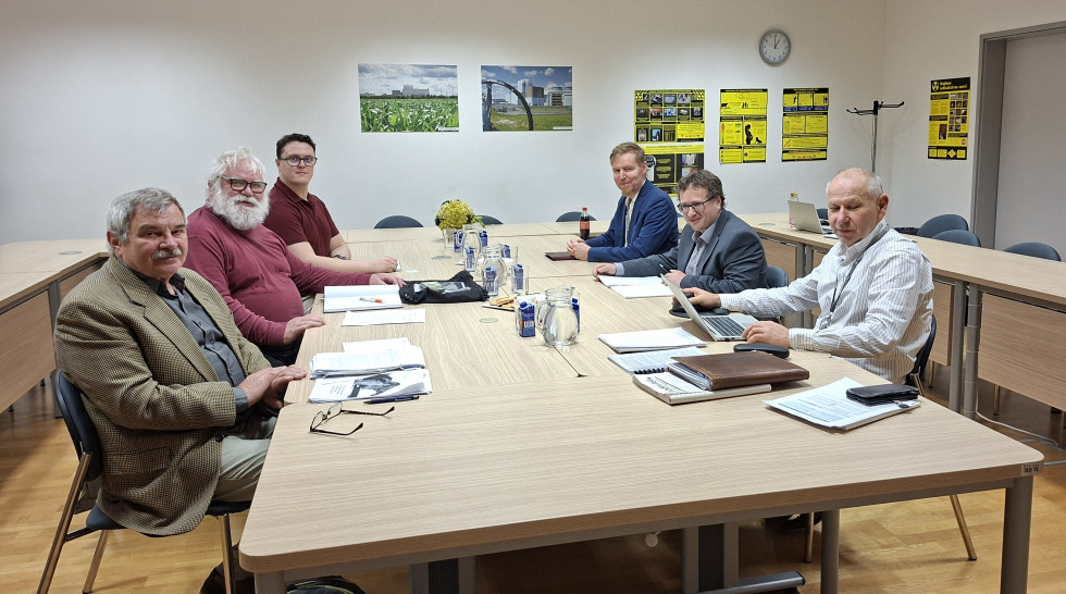 Udeleženci srečanja sedijo za mizo. Na vsaki strani so trije udeleženci.