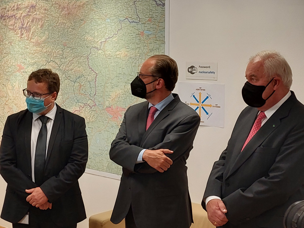 Direktor URSJV, avstrijski zunanji minister in deželni glavar avstrijske Štajerske z maskami, v ozadju zemljevid.