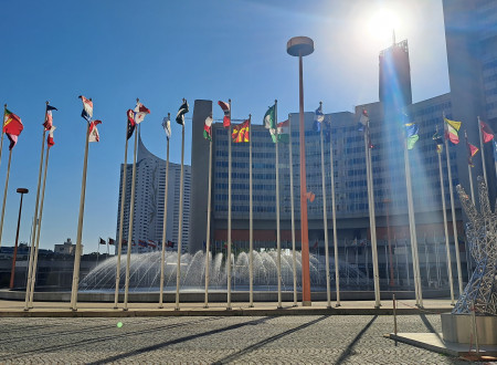 Pogled na zgradbo IAEA, spredaj plapolajo zastave članic