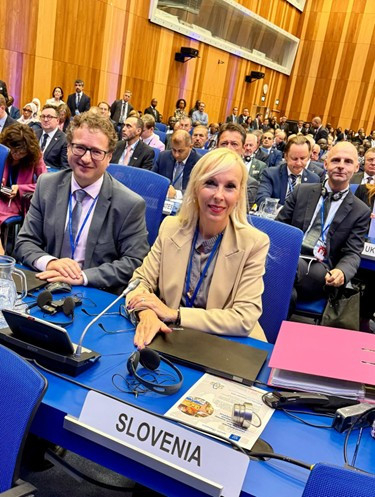 veleposlanica in direktor za mizo slovenske delegacije, v ozadju še tuji udeleženci